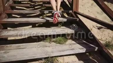 女孩<strong>跑步</strong>者从码头爬上木制楼梯。 <strong>跑步</strong>运动员在楼梯上<strong>跑步</strong>。